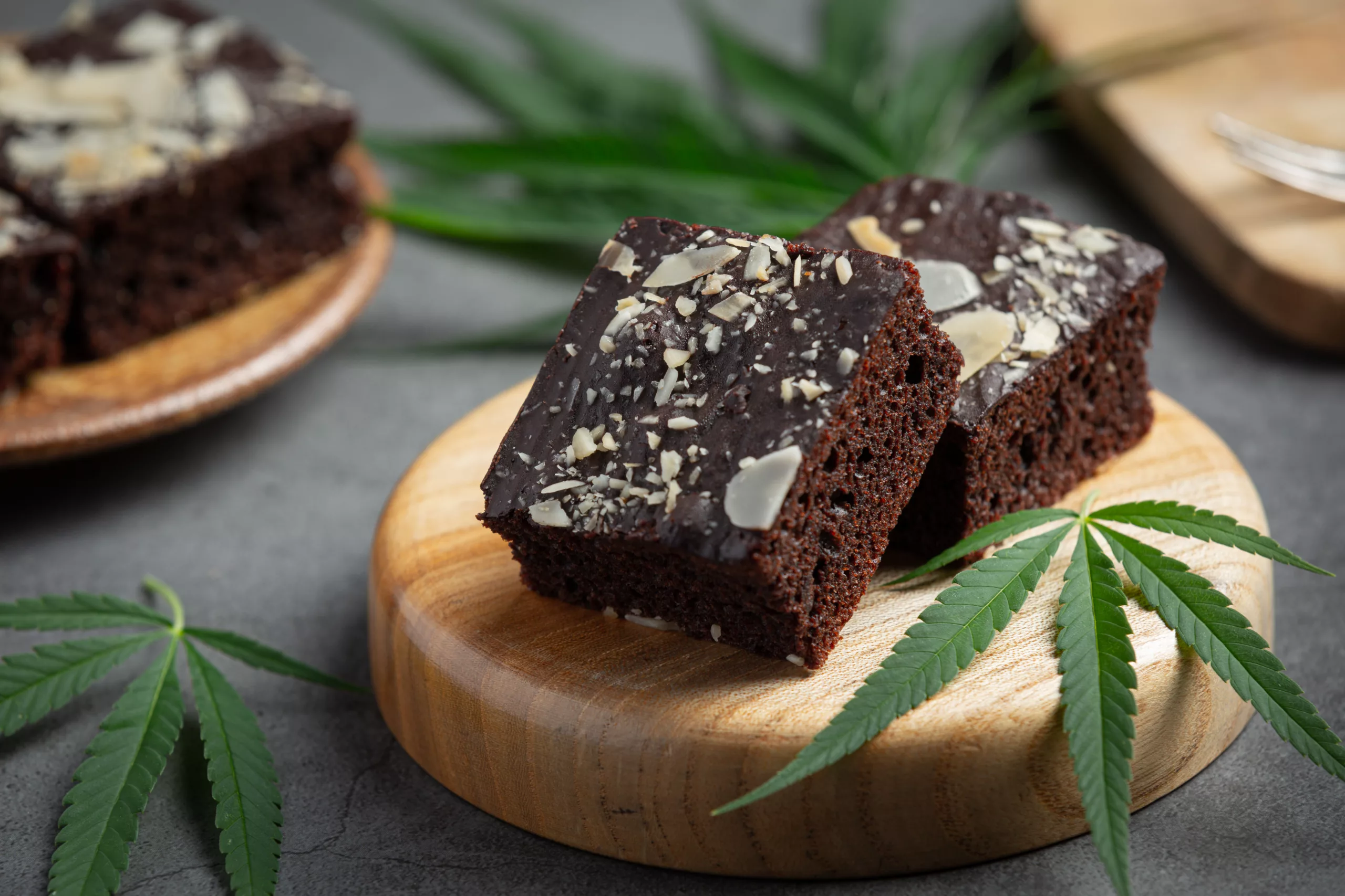 cannabis brownies and cannabis leaves put on wooden cutting boar